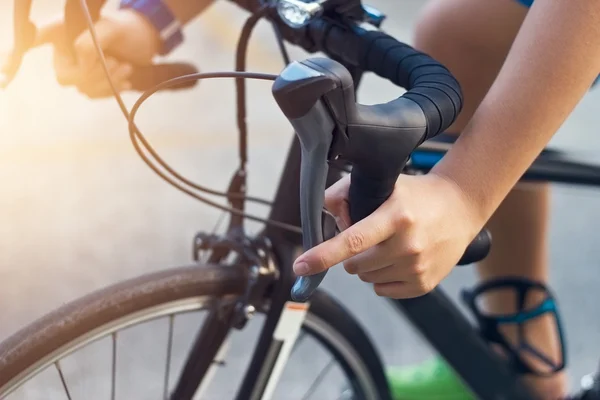 Cerca de las manos y el manillar de un joven ciclista en la calle — Foto de Stock