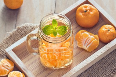 ahşap arka plan üzerinde mug içinde portakal infusioned su