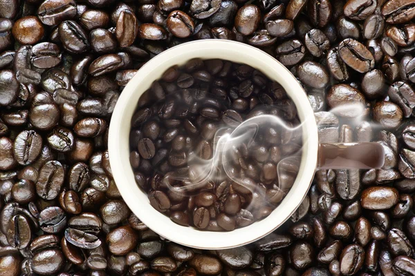 Granos de café y humo sobre fondo de granos de café originales — Foto de Stock