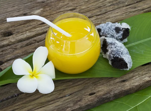 Fresh orange juice and donut on the leaf and wooden — Stock Photo, Image