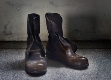 Mavi grunge arka plan üzerinde kirli eski kahverengi botları