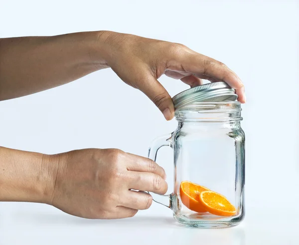 Fetta di arancia in tazza e mano su sfondo grigio, Apri — Foto Stock