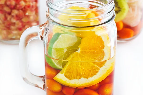 Mug délicieuse boisson rafraîchissante de fruits mélangés colorés sur fond blanc — Photo