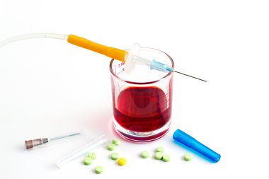 şırınga ve cam ölçü ve beyaz zemin üzerine hap