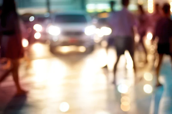 La gente abstracta camina en la noche de la calle en la ciudad, pastel y borroso concepto — Foto de Stock