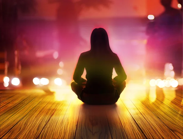 Mujer está meditando por la noche y rayos de luz en la ciudad —  Fotos de Stock