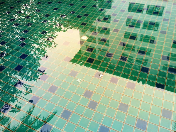 Reflexão edifício abstrato na água da piscina colorida — Fotografia de Stock