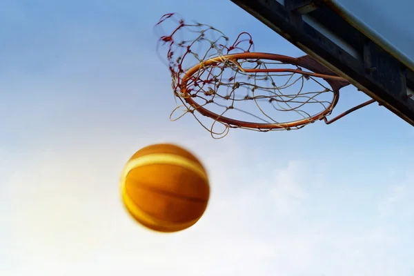 Koszykówka przechodzi do kosza w na tle błękitnego nieba — Zdjęcie stockowe