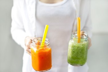 Freshsmoothies sebze havuç marul Detoks ve yumuşak odak, pastel arka plan içinde salatalık eller