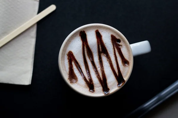 Chocolate quente em caneca branca no fundo escuro, vista superior — Fotografia de Stock