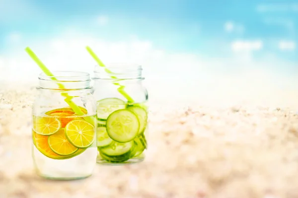 Infused water lime and cucumber in mug on sea sand beach summer day — Stock Photo, Image