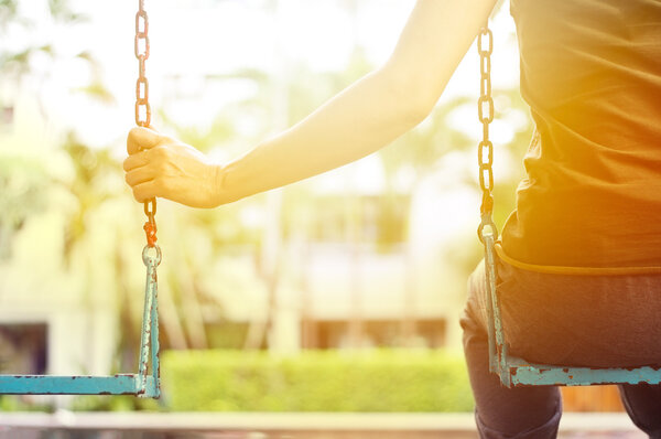 Lonely woman missing her boyfriend while swinging in the park of village