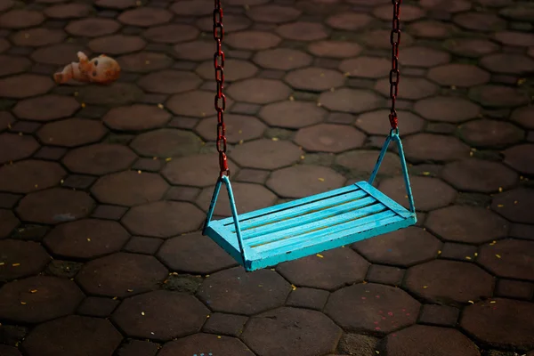 Soltero azul swing personas vacías y muñeca en la noche oscura —  Fotos de Stock