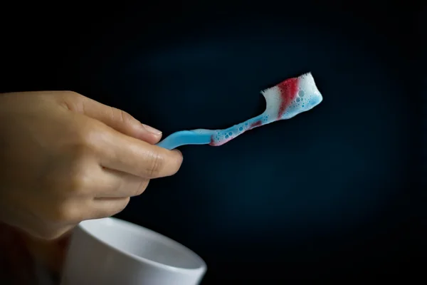 Toothbrush with scurvy in a bubble toothpaste on  dark background — Stock Photo, Image