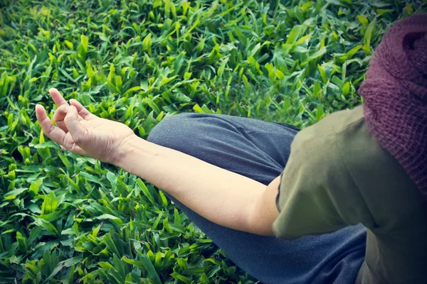 Mulher ioga meditando ao ar livre no parque no fundo do campo de grama, Foco na mão, Vista superior — Fotografia de Stock