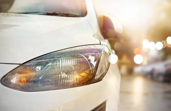 Colorful headlight of white car after the rain at night — Stock Photo, Image