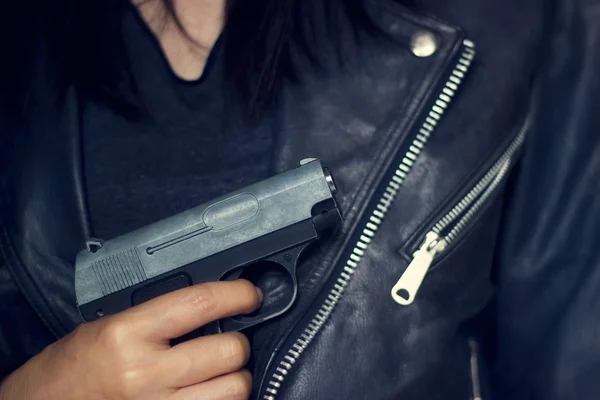 Mujer con pistola en la mano, llevaba chaqueta negra textura de fondo —  Fotos de Stock