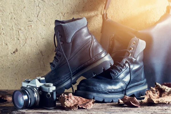 Пара чоловічих чорних черевиків з сухим листям на дерев'яному фоні — стокове фото