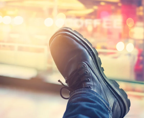 Botas pretas masculinas em fundo de madeira e cidade — Fotografia de Stock