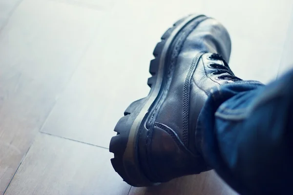 Botas masculinas de couro preto no fundo chão de madeira — Fotografia de Stock