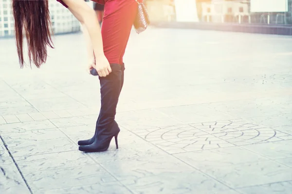 Patas de mujer en tacones altos botas negras sobre fondo de calle, concepto suave y borroso — Foto de Stock