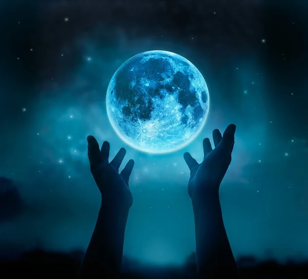 Abstract hands while praying at blue full moon with star in dark night sky — Stock Photo, Image