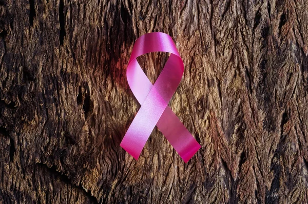 Pink ribbon, breast cancer awareness symbol on wooden background