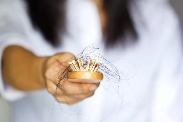 Mujer perder el pelo en el cepillo de pelo en la mano, enfoque suave — Foto de Stock