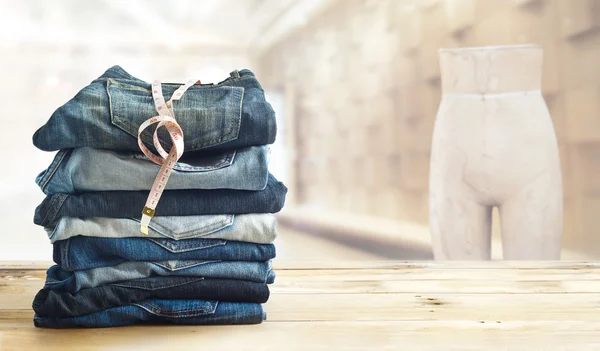 Jeans com medida na loja na prateleira de madeira e interior — Fotografia de Stock