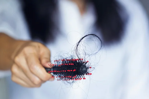 Donna che perde i capelli sulla spazzola in mano, messa a fuoco morbida — Foto Stock