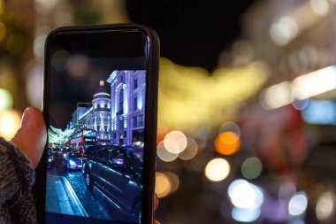 İngiltere 'de cep telefonuyla Noel Londra' sının fotoğrafını çekiyor.