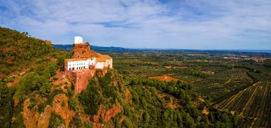 İspanya 'daki Mare de Deu de la Roca de Mont-roig' in havadan görünüşü kayalık tırmanış alanları, panoramik manzarası ve tarihi bir kilise ile engin tepe tırmanış rotası.