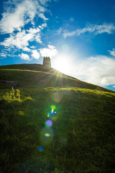 Glastonbury Tor near Glastonbury in the English county of Somerset, topped by the roofless St Michael 's Tower, UK