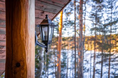 Kışın ormandaki ahşap evin feneri.