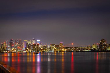Londra, İngiltere 'deki Canary Wharf ve Thames bariyerlerinin uzun pozlama görüntüsü