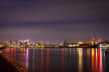 Londra, İngiltere 'deki Canary Wharf ve Thames bariyerlerinin uzun pozlama görüntüsü