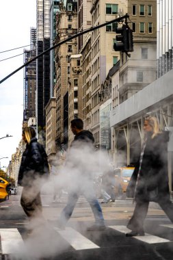 Trafik ve bayraklar hafifçe bulanık, kentsel altyapı, enerji ve kış hava durumu editörleri için ideal New York City Bulvarı 'ndaki rögar kapağından yoğun buhar dalgaları