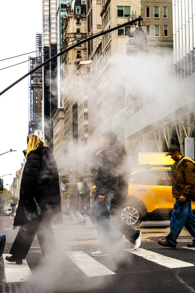Trafik ve bayraklar hafifçe bulanık, kentsel altyapı, enerji ve kış hava durumu editörleri için ideal New York City Bulvarı 'ndaki rögar kapağından yoğun buhar dalgaları