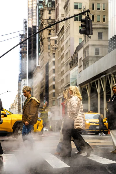 Trafik ve bayraklar hafifçe bulanık, kentsel altyapı, enerji ve kış hava durumu editörleri için ideal New York City Bulvarı 'ndaki rögar kapağından yoğun buhar dalgaları