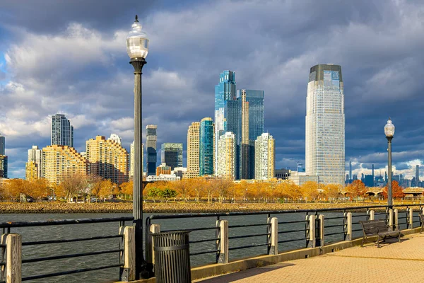 New Jersey Hudson Nehri 'ndeki fırtına bulutlarının altında nehir kenarındaki sokak lambasının arkasındaki gökyüzü; seyahat reklamları, gayrimenkul ve finans için ideal.