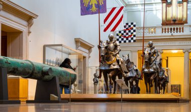 Turistler zırhlı şövalyeleri ve atları müzenin silah ve zırhlı sergisinde görüyorlar; seyahat, tarih, eğitim, kültür, müze promosyonları, editoryal kullanım için ideal