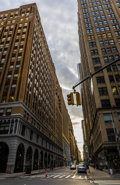 New York 'ta sakin bir kavşağın dramatik sokak manzarası. Yüksek kaliteli binalar ve kasvetli bulutlu ışık güçlü kentsel hatlar oluşturuyor. Finans haberleri, emlak reklamları, şehir markalaşması için ideal.