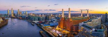Alacakaranlıkta Thames Nehri 'nin yanındaki Battersea Elektrik İstasyonu' nun etrafında Noel ışıkları parıldıyor. Londra 'nın ufuk çizgisi ise tatil seyahati, emlak ve kentsel markalaşma için mükemmel.