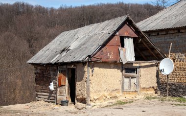 Batı Ukrayna 'daki bir Roma köyünde televizyon-uydu anteni olan fakir bir evde.