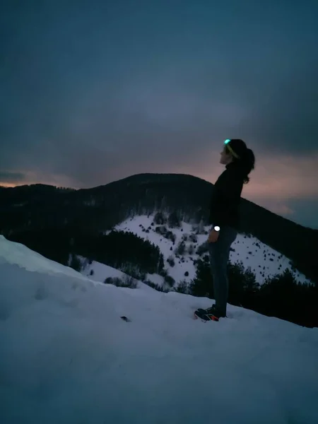 在雪山里戴大灯的年轻女子 — 图库照片