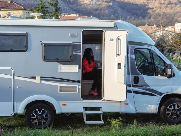 Genç bir kadın bir karavana oturdu. 