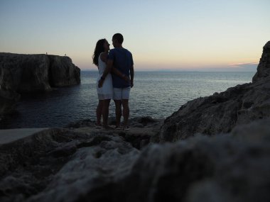 Menorca uçurumunda bir çiftin silueti.