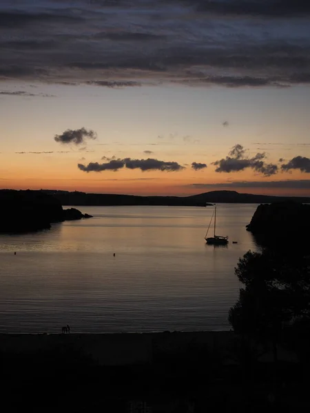 silhouette of a boat in a bay in Menorca