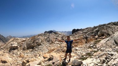 Genç adam dağlarda yürüyüş yapıyor.