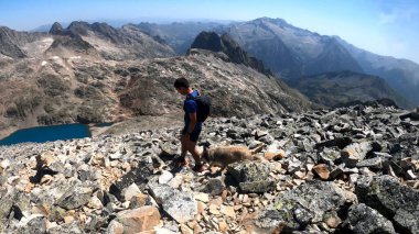 Genç adam dağlarda yürüyüş yapıyor.